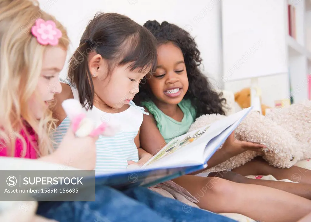 Girls reading book together