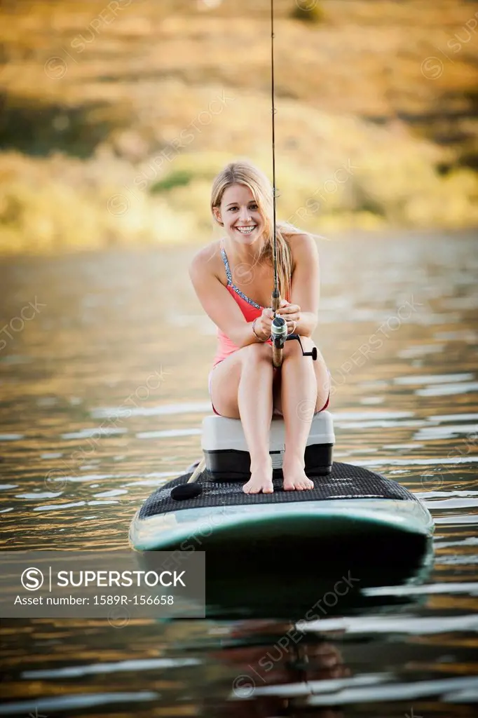 Caucasian woman fishing in lake