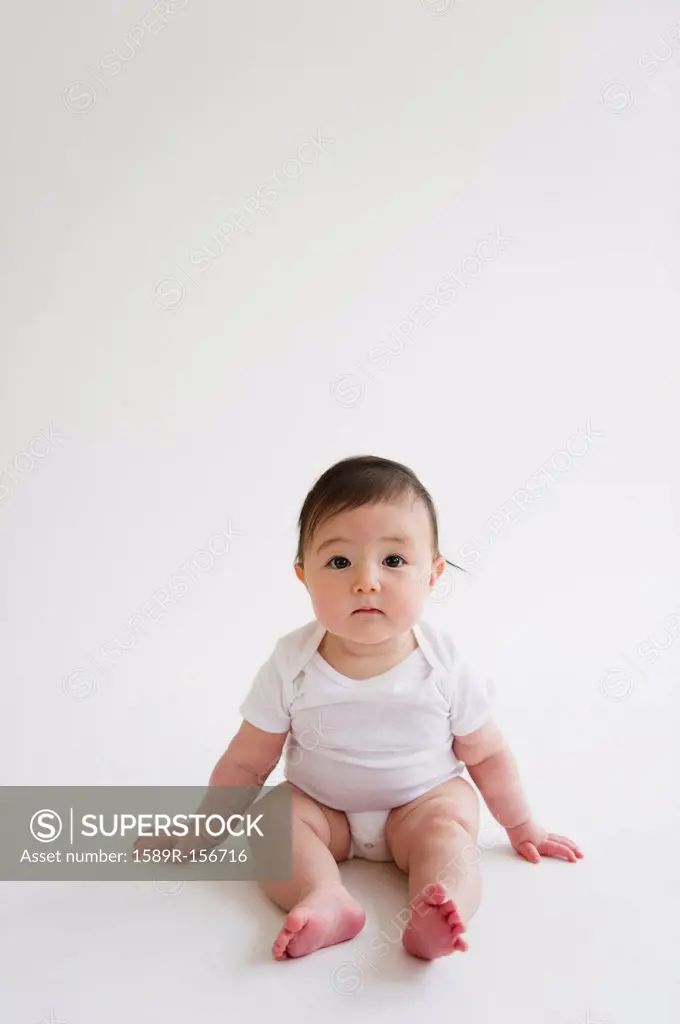Asian baby girl sitting on floor