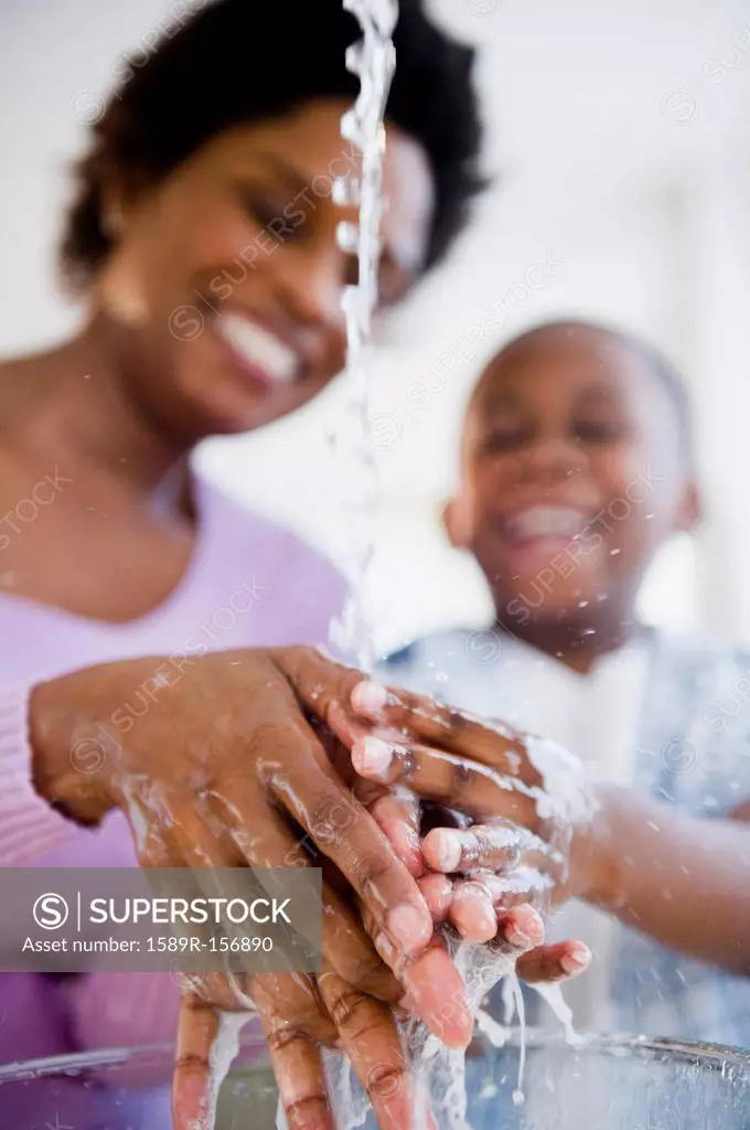 Black mother and son washing hands