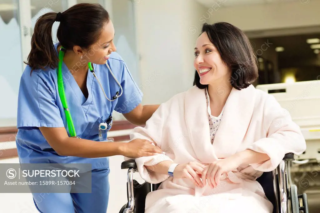 Nurse talking to patient in wheelchair in hospital