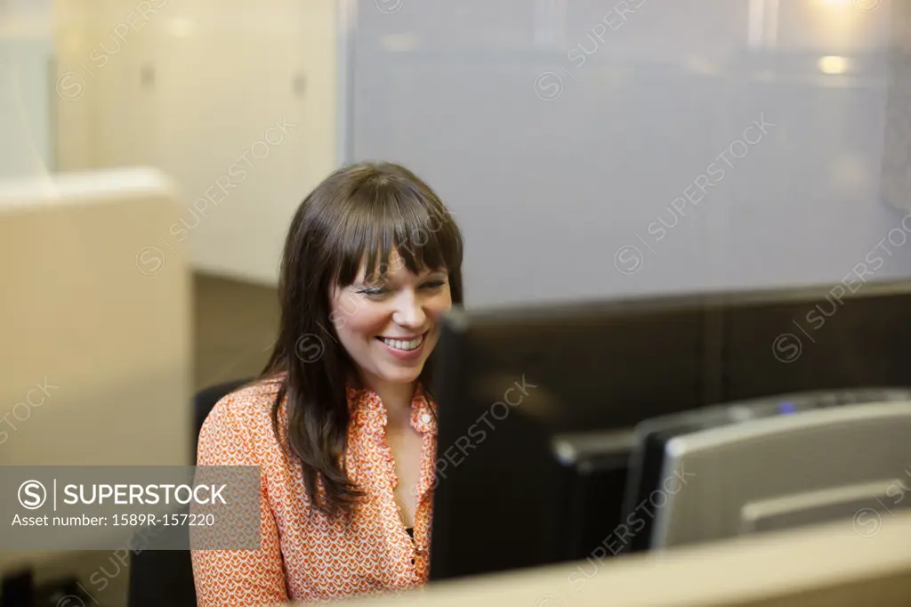 Caucasian businesswoman using computer in office