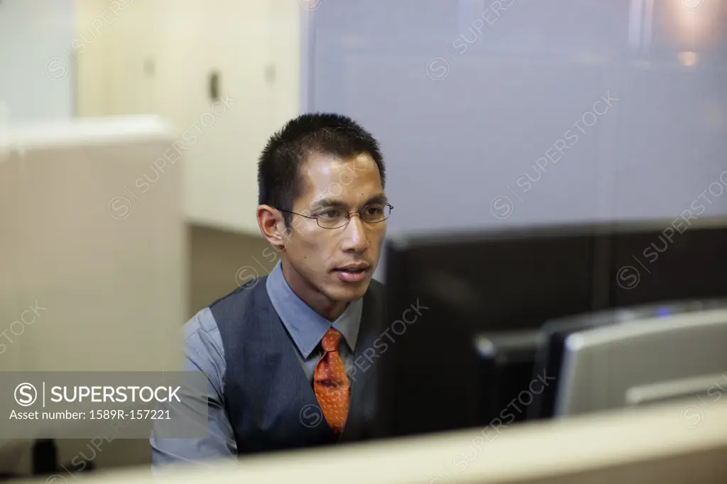 Mixed race businessman using computer in office