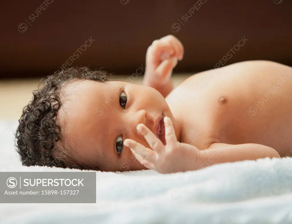 Mixed race newborn baby laying on blanket