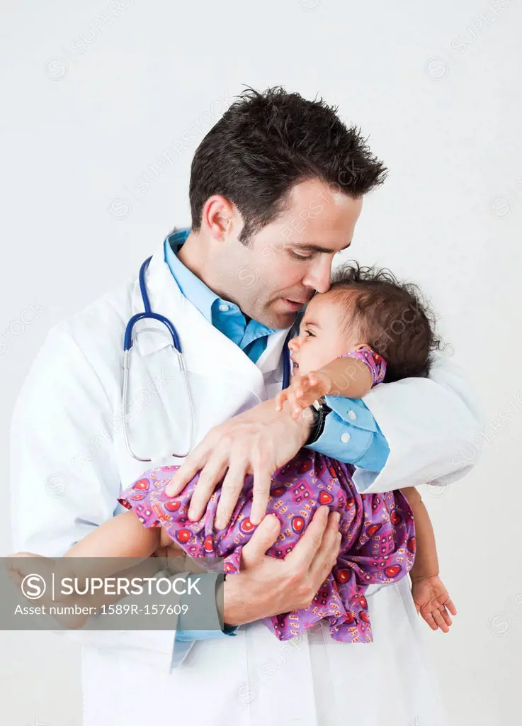 Doctor comforting baby girl