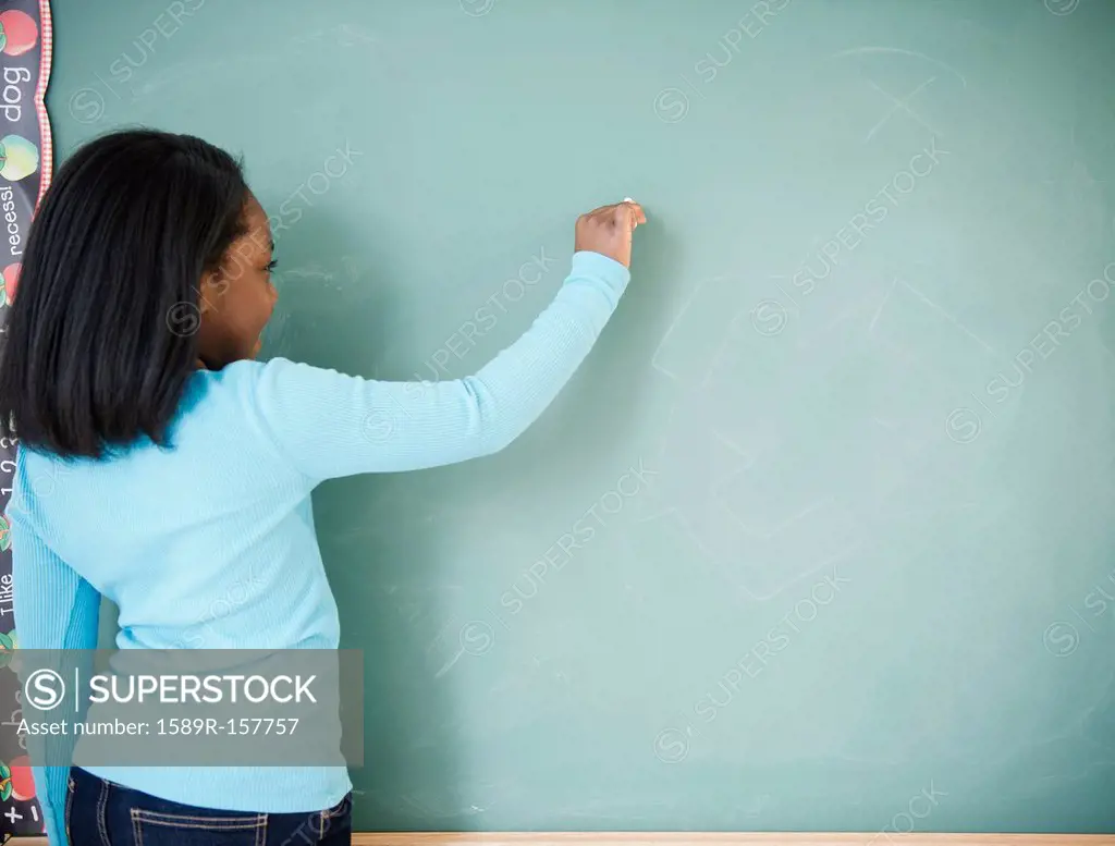 Black student writing on blackboard