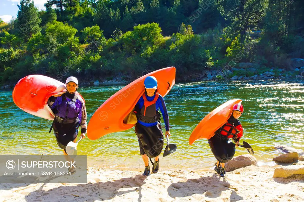 Caucasian family carrying kayaks