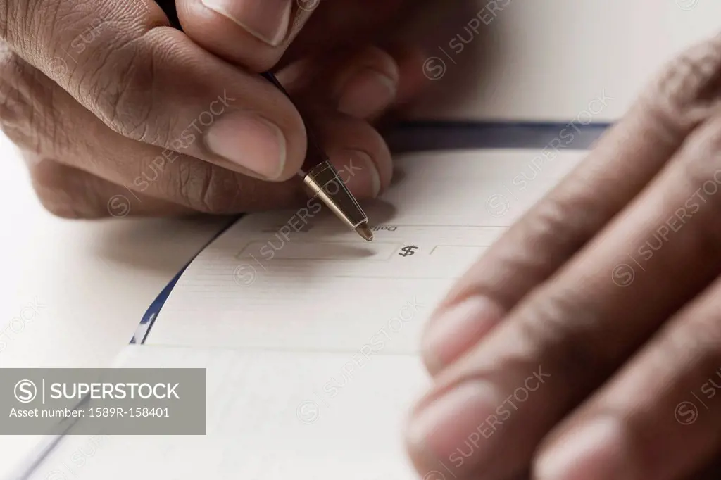 Mixed race man writing a check