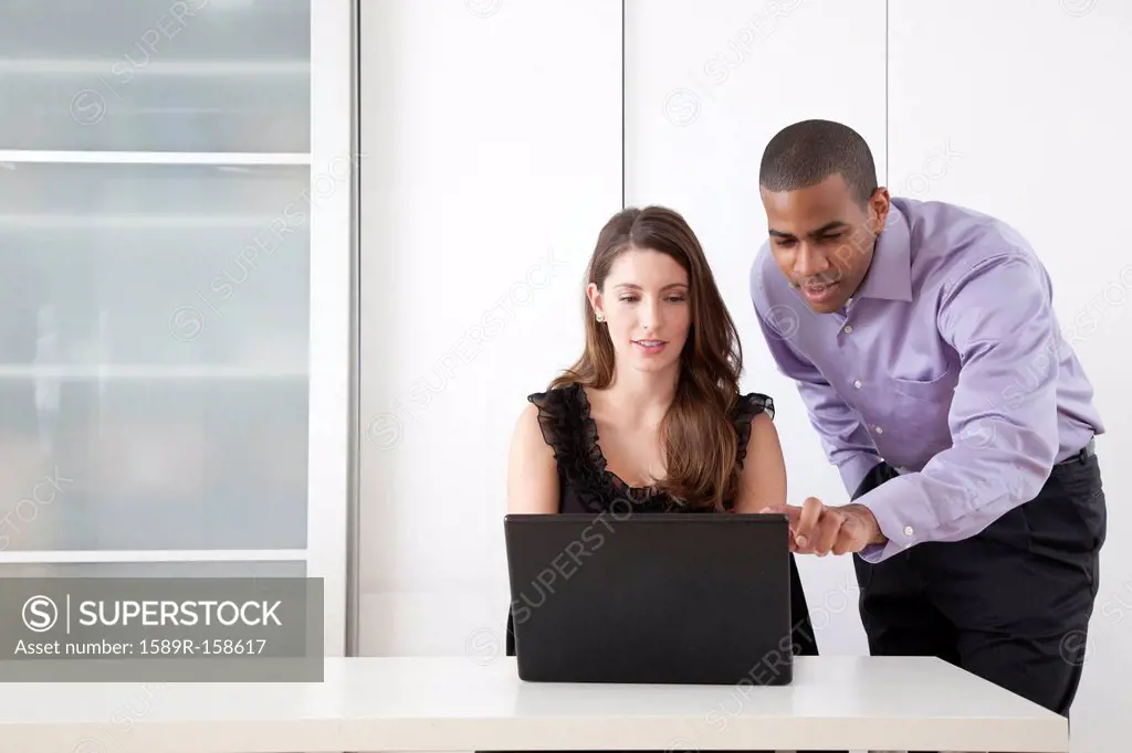 Business people using laptop together