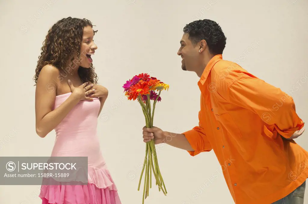 Young man giving girlfriend a bunch of flowers