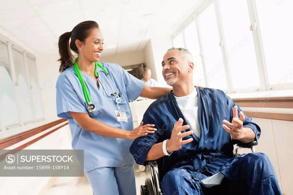 Nurse comforting patient in wheelchair in hospital