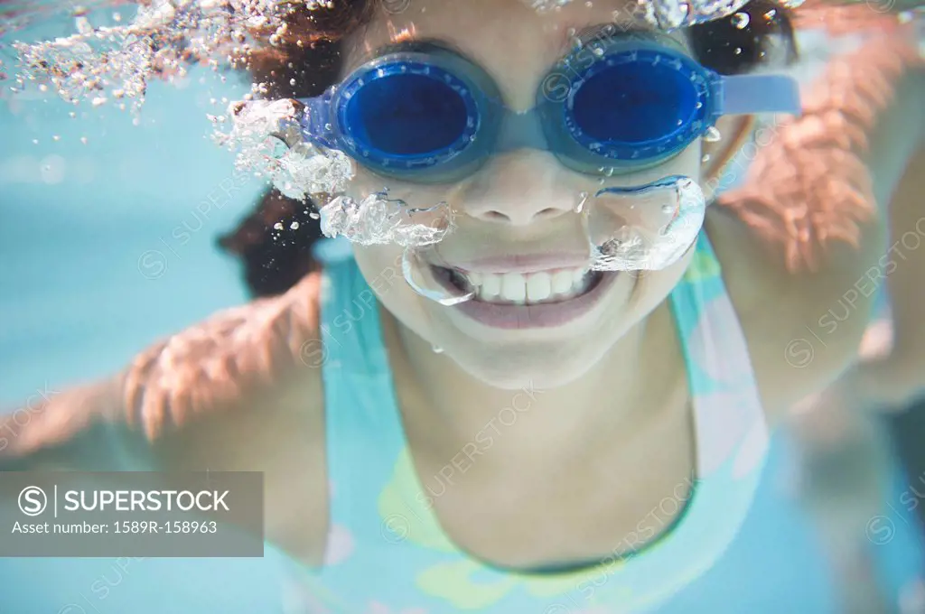 Hispanic girl swimming under water