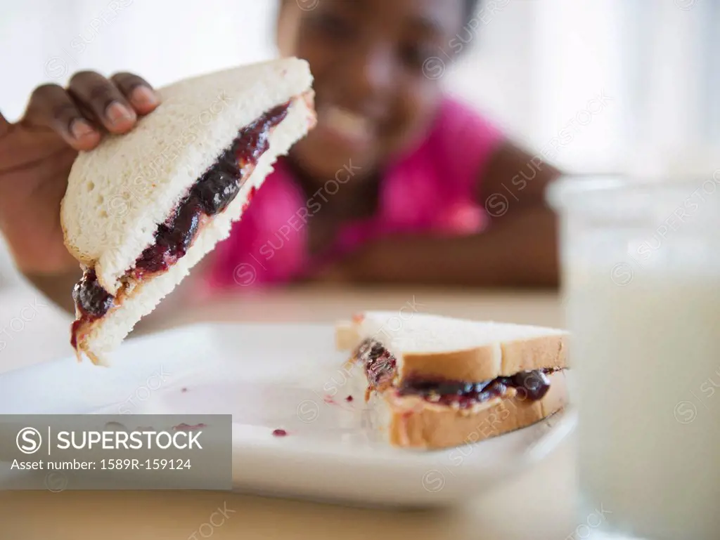 Black girl eating peanut butter and jelly sandwich