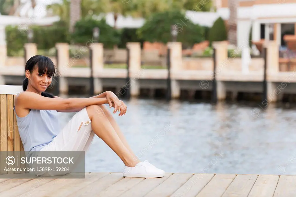 Mixed race woman sitting on pier