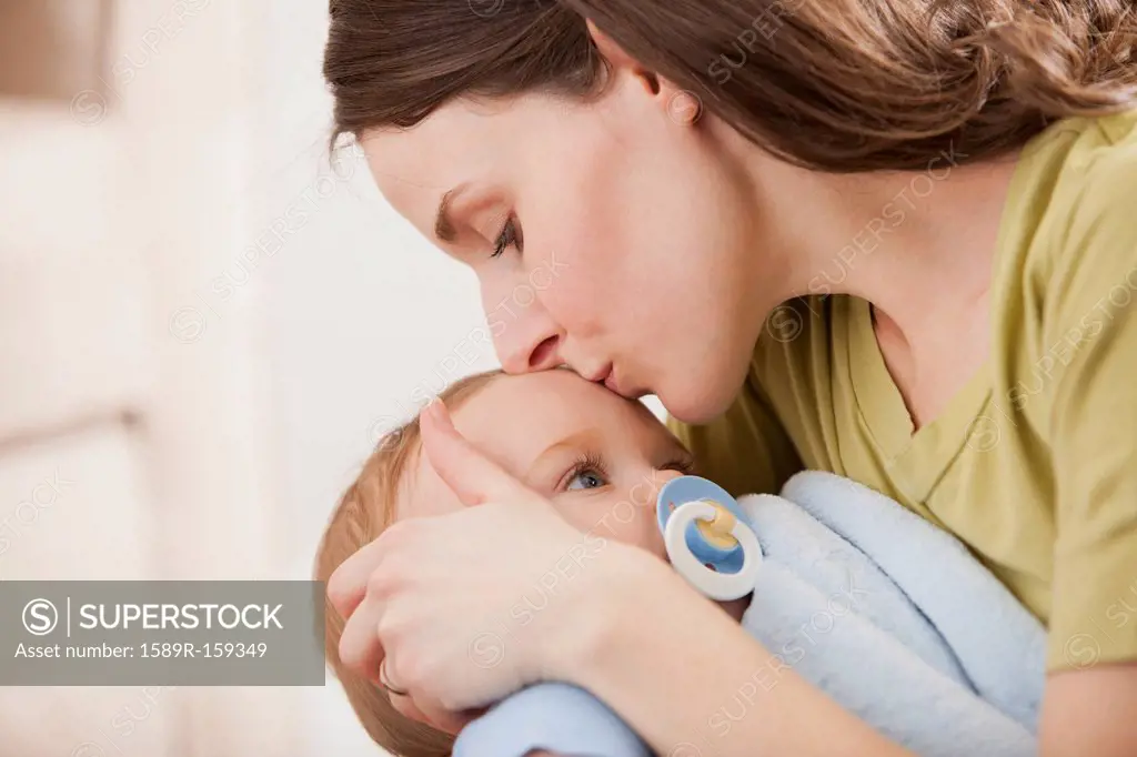 Caucasian mother kissing baby boy