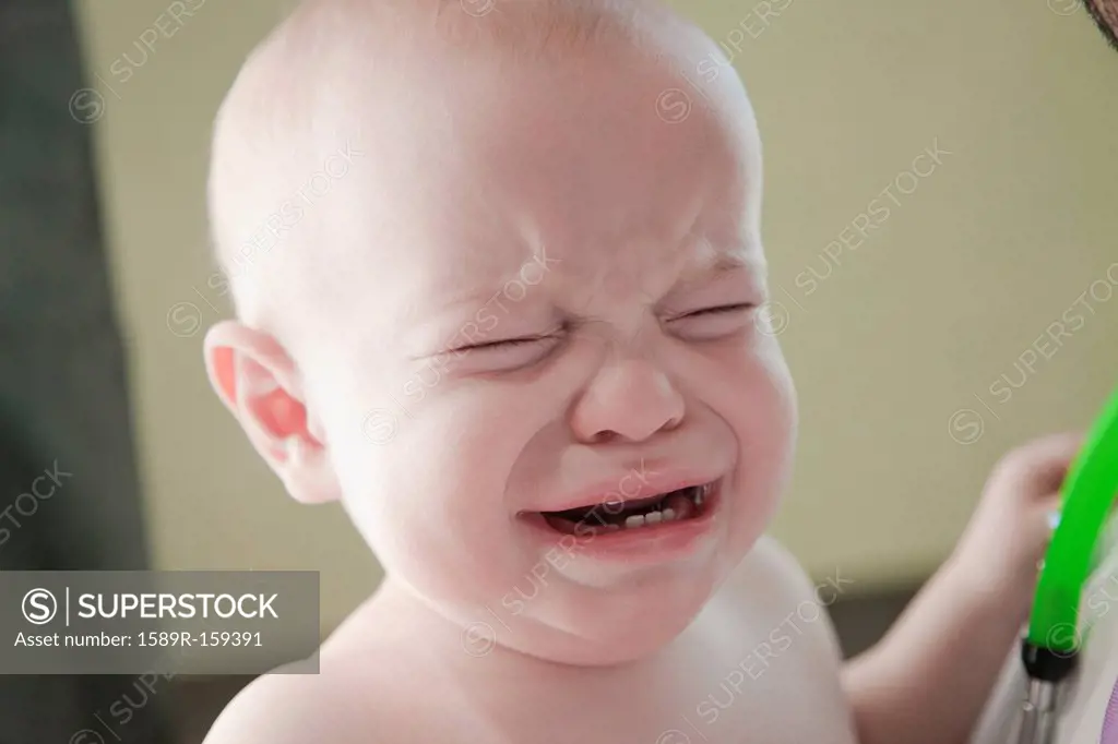 Crying mixed race baby in doctor´s office