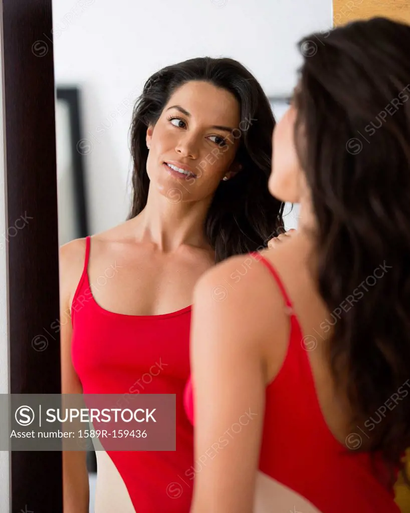 Hispanic woman looking at her reflection