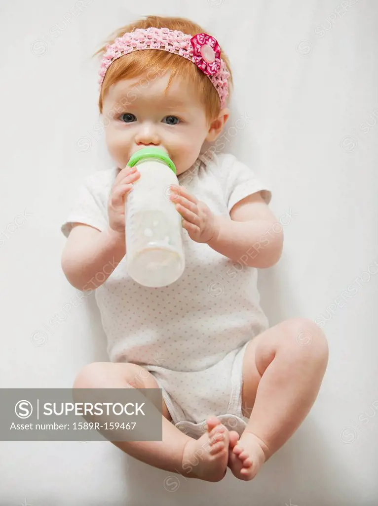 Caucasian baby girl drinking bottle