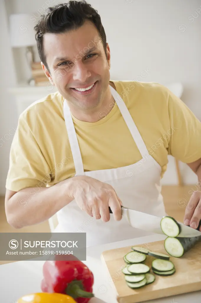 Mixed race man slicing vegetables