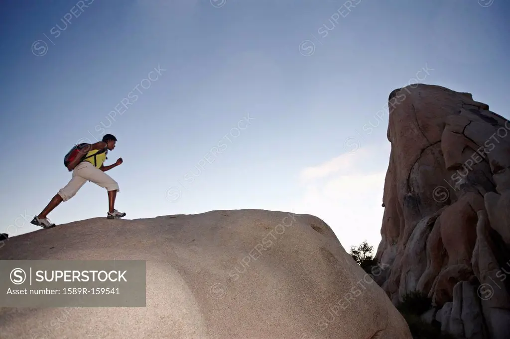 Woman hiking on large rock