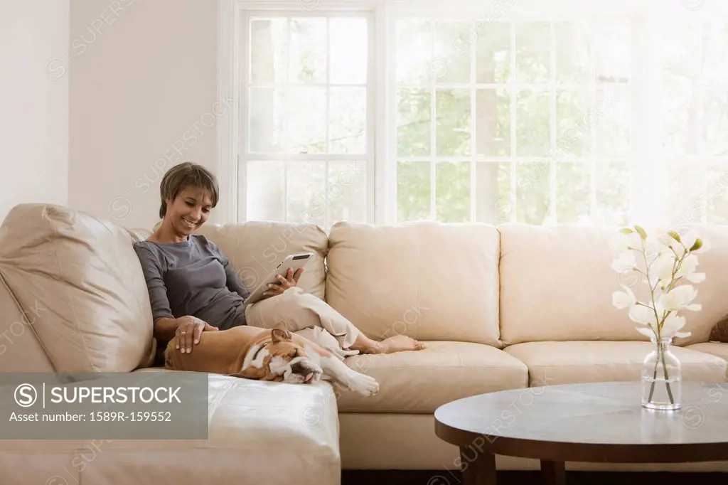 Native American woman relaxing on sofa with English bulldog