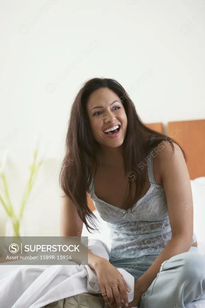Woman in bed laughing