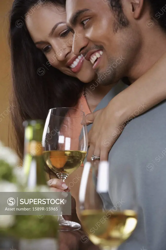Close up of couple hugging and drinking wine