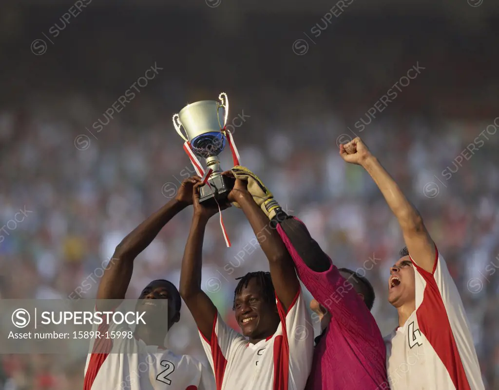 Soccer team triumphantly holding up trophy