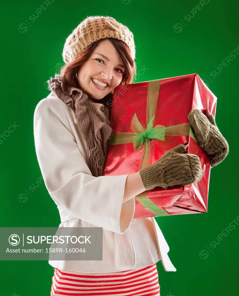 Mixed race woman holding Christmas gift