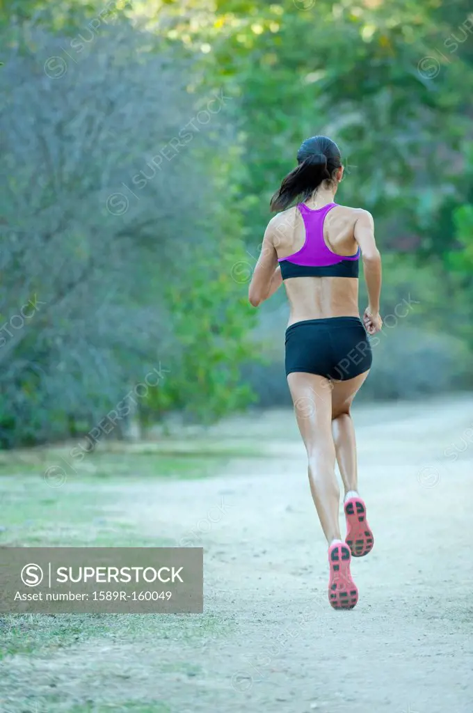 Hispanic woman running on remote path