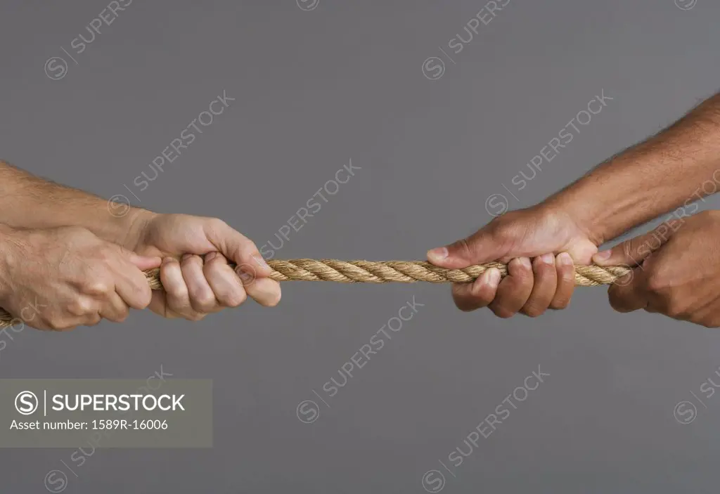 Close up of tug-o-war with four hands