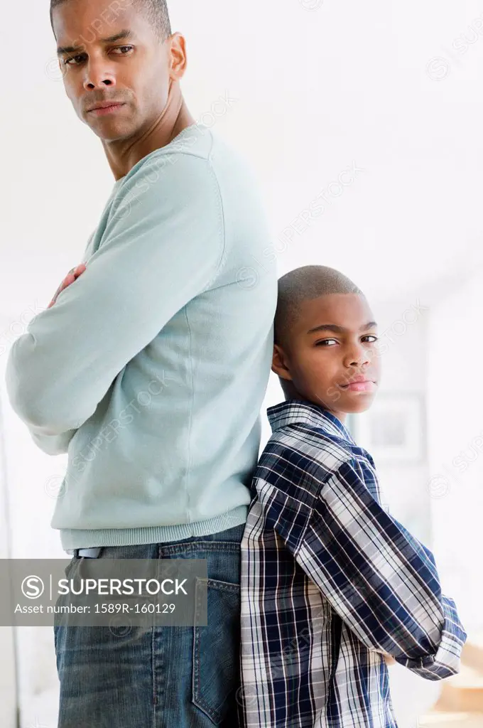 Stubborn father and son standing back to back