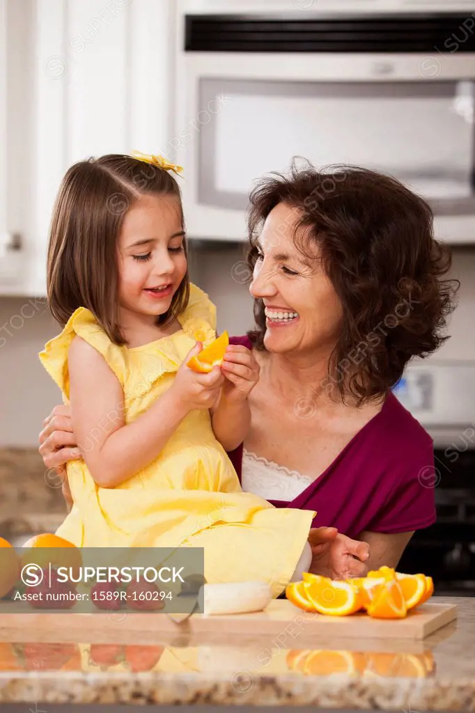 Caucasian grandmother and granddaughter eating fruit
