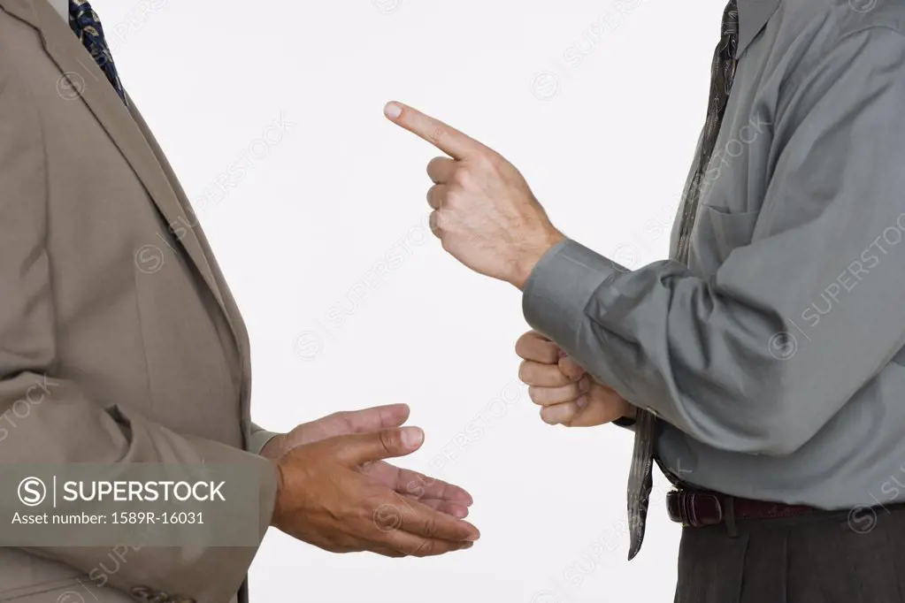 Mid section of two businessmen facing each other with hands gesturing