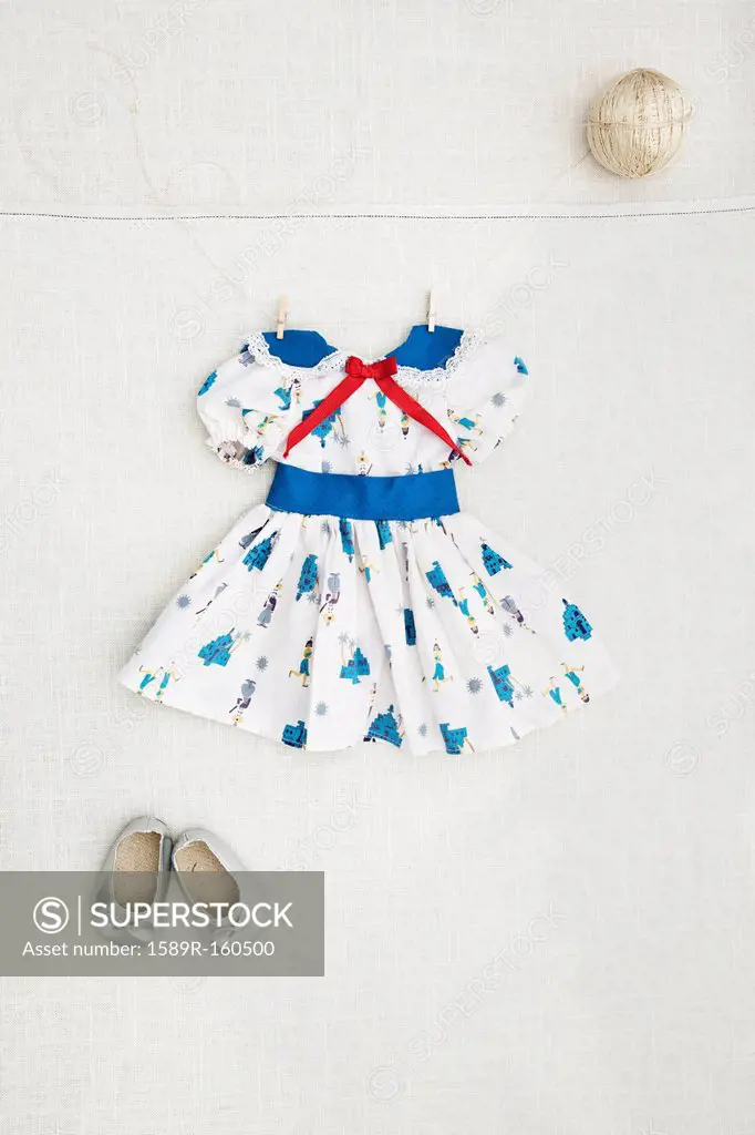 Girl´s dress and shoes hanging on wall