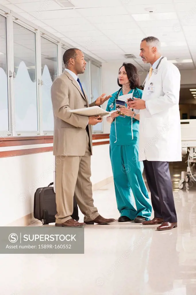 Doctors and drug salesman talking in hospital