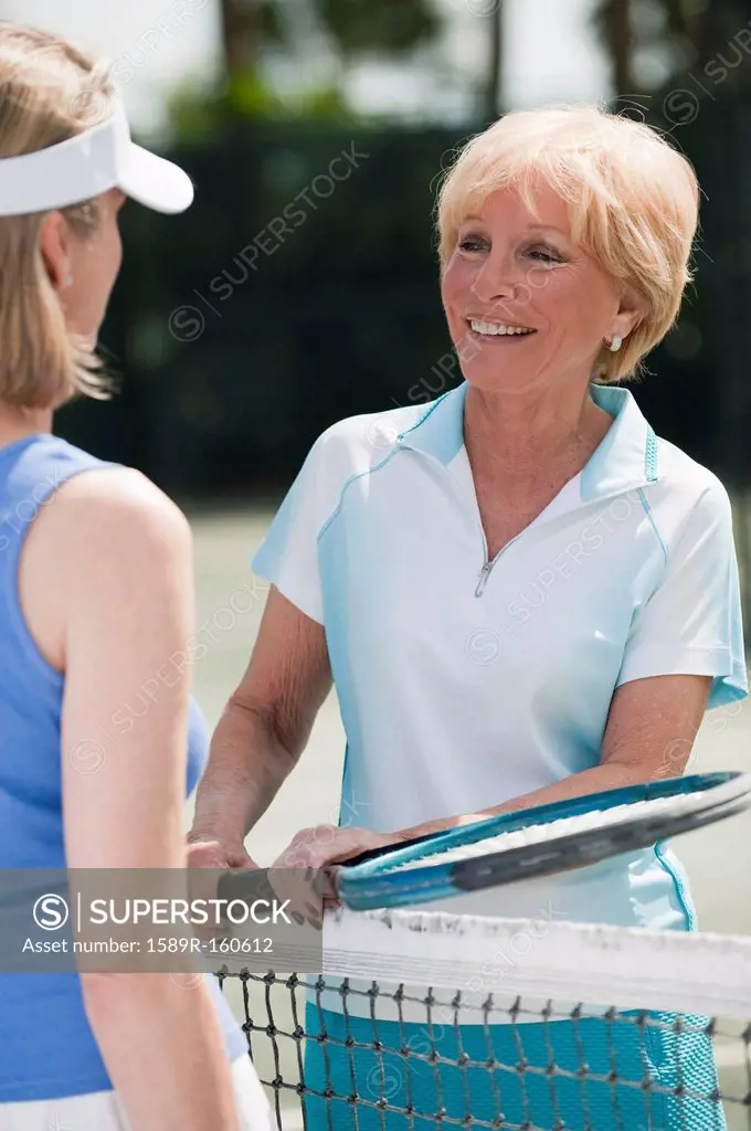 Caucasian women playing tennis