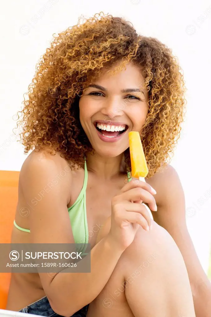 Mixed race woman eating popsicle