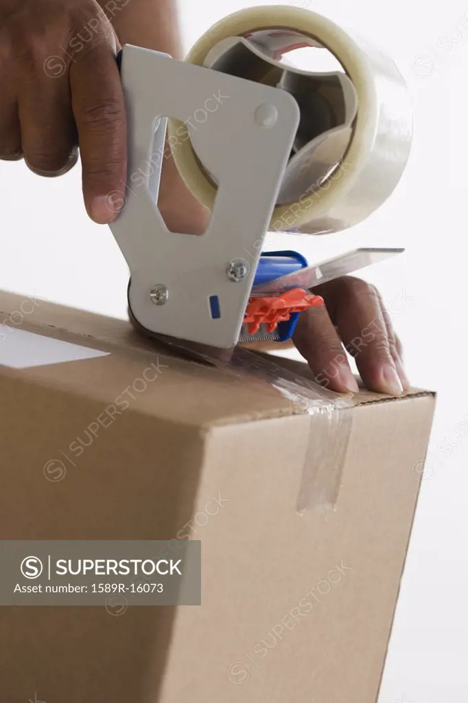 Close up of hands taping up box