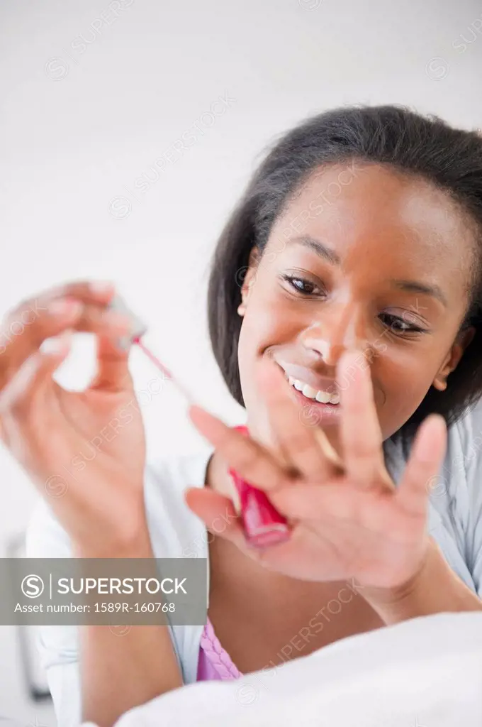 Black woman painting her fingernails