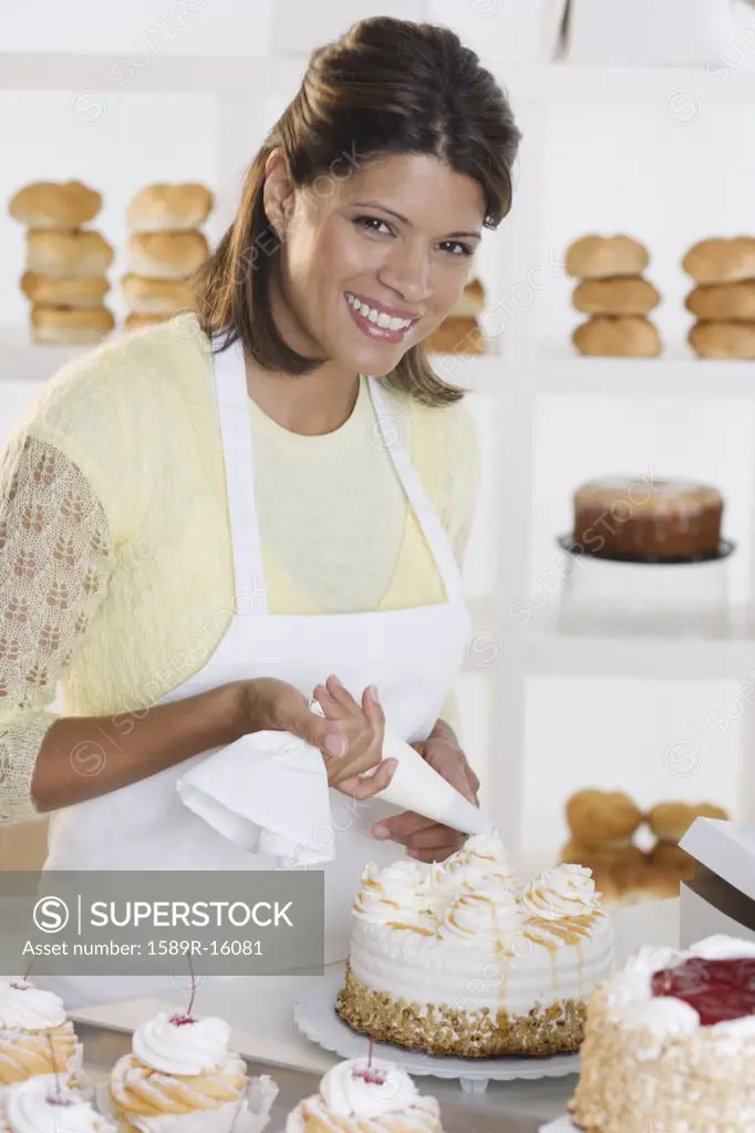 Portrait of woman decorating cake at bakery