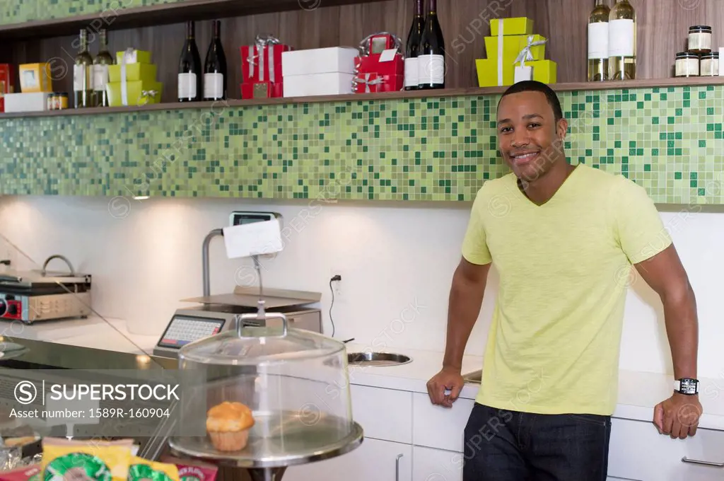 Mixed race business owner leaning on shop counter