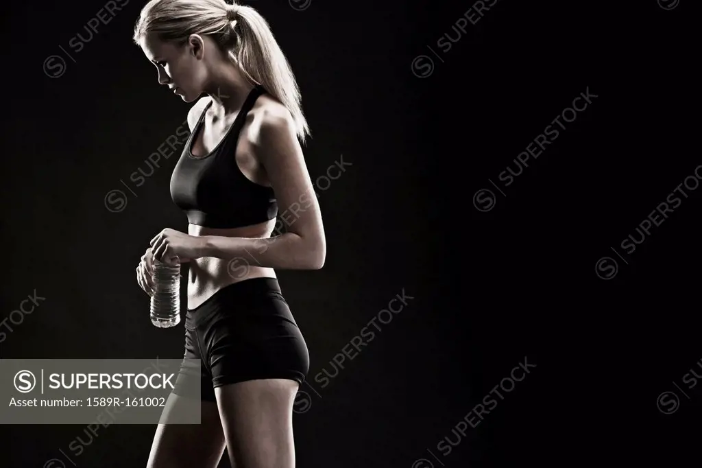 Caucasian woman drinking water after exercise