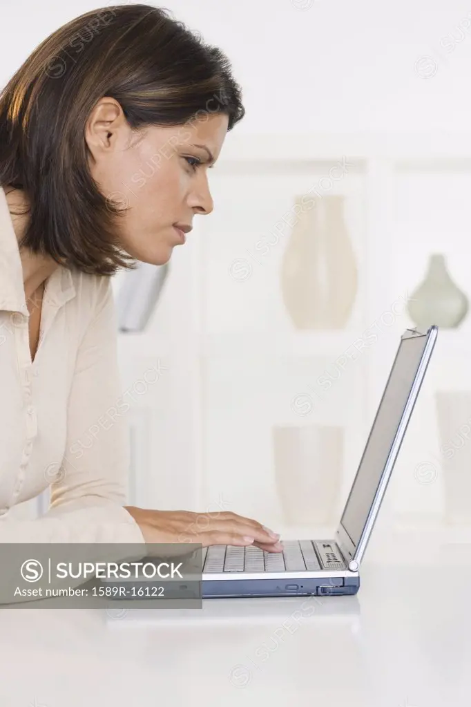 Profile of woman working on laptop