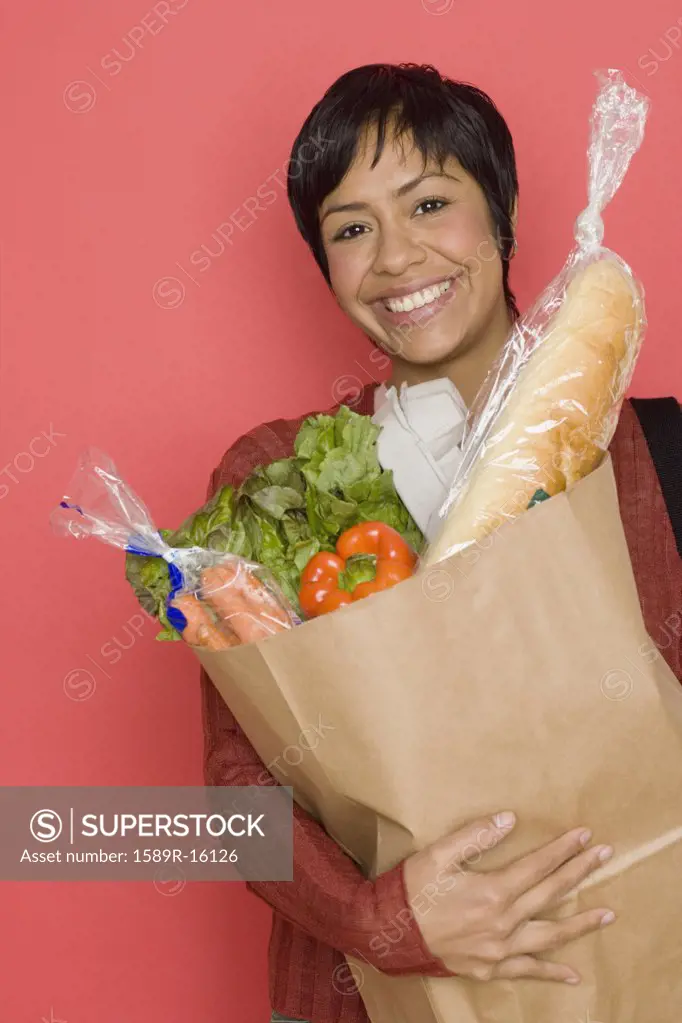 Portrait of woman holding bag of groceries