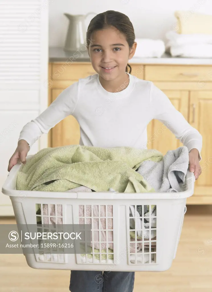 Young girl holding a laundry basket