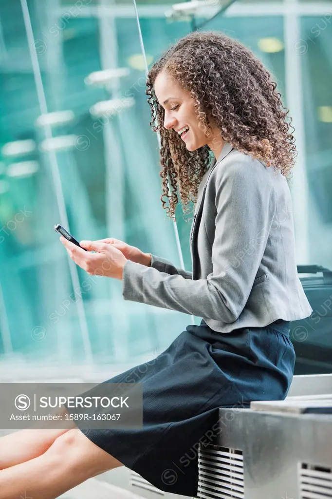 Caucasian businesswoman text messaging on cell phone