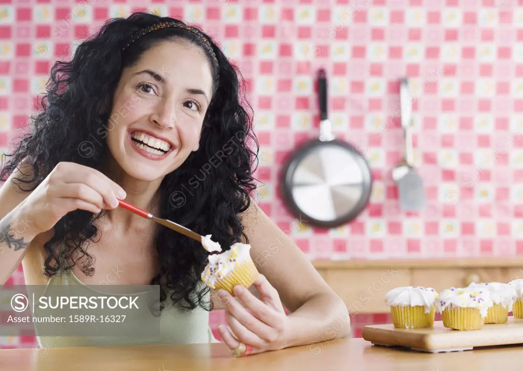 Young woman frosting cupcakes