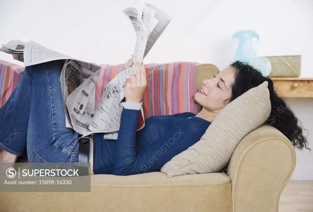 Young woman reading the newspaper