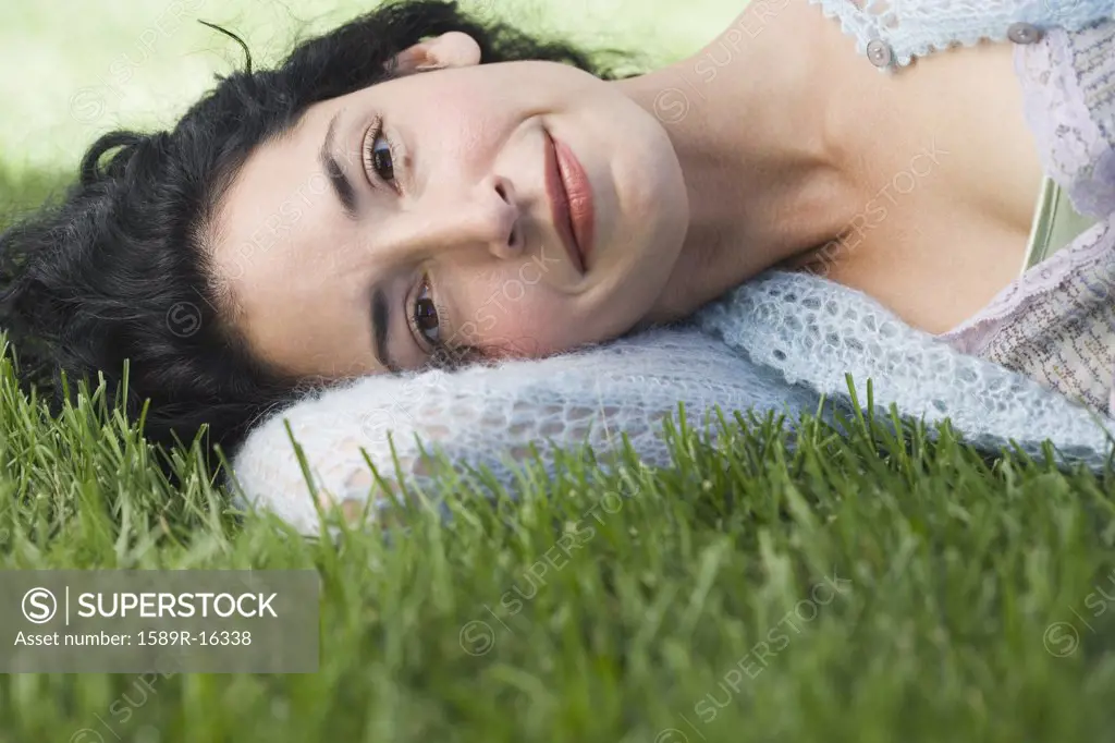 Young woman laying on grass